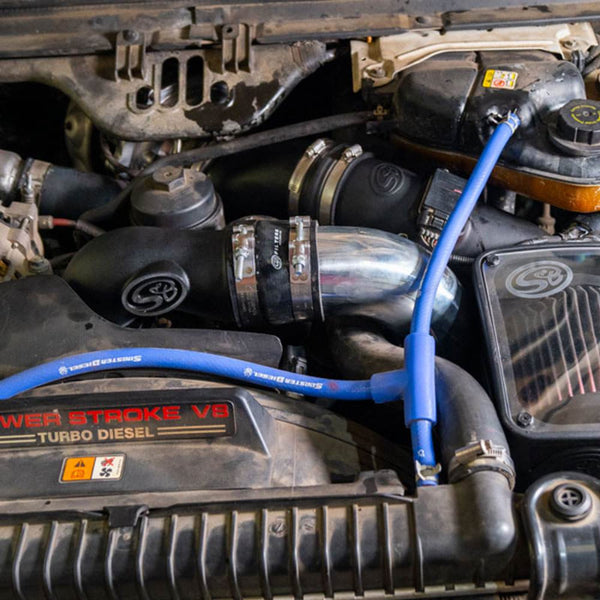 An SB Intake Elbow with Cold Side Intercooler Piping & Boots for 2005-2007 Ford Powerstroke 6.0L installed in a car